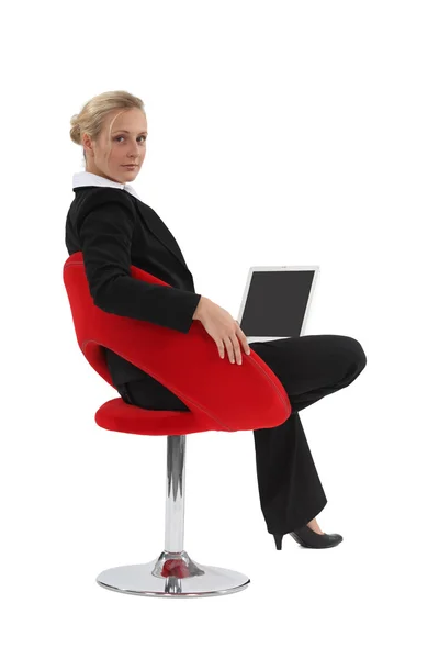 Kvinna sitter i en stol och använder sin laptop — Stockfoto