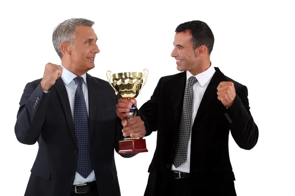 Успешные бизнесмены держат золотой кубок — стоковое фото