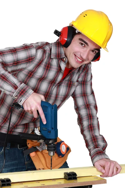 Genç bir matkap kullanarak tüm gülümsüyor marangoz — Stok fotoğraf