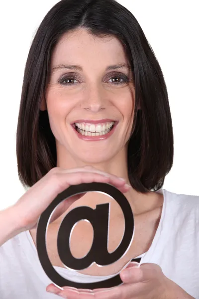 A woman showing an @ — Stock Photo, Image