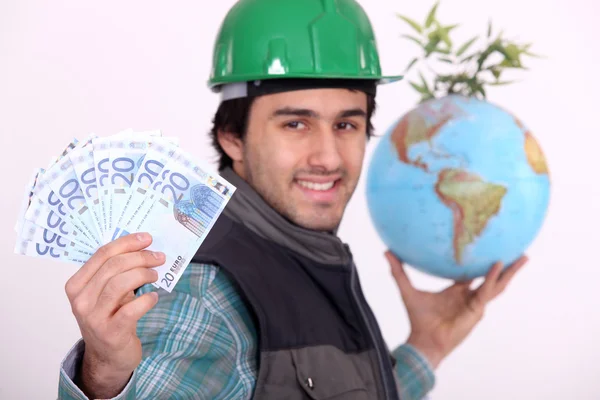 Arbeider holding globe en contant geld — Stockfoto