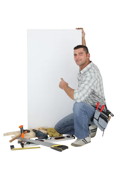 Carpinteiro posando por painel de publicidade — Fotografia de Stock