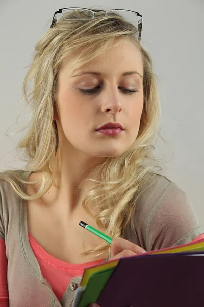 stock image Blonde woman with downcast eyes writing