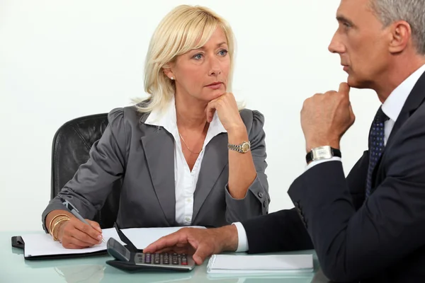 Mature business couple at a desk Stock Photo