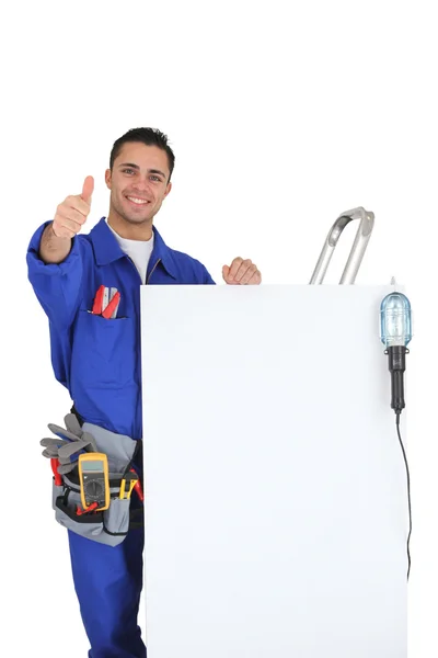 Artisan near a white panel doing thumbs up Stock Picture