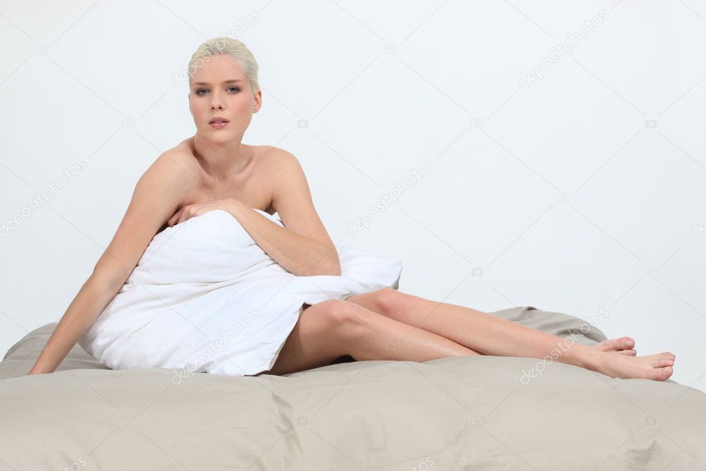 Morning of beautiful young woman sitting on bed at home 