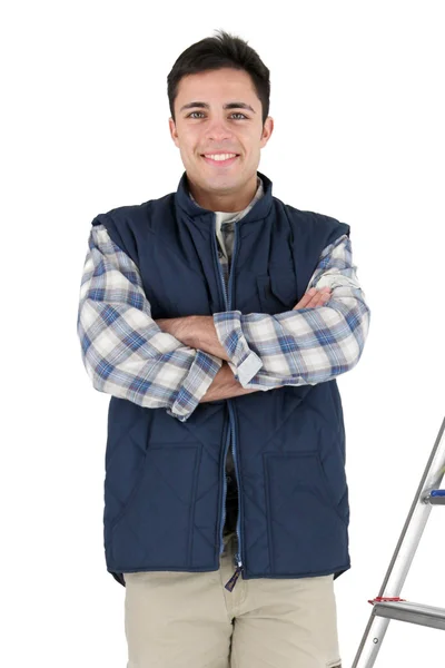 Craftsman standing cross-armed in studio with ladder and tools — Stock Photo, Image