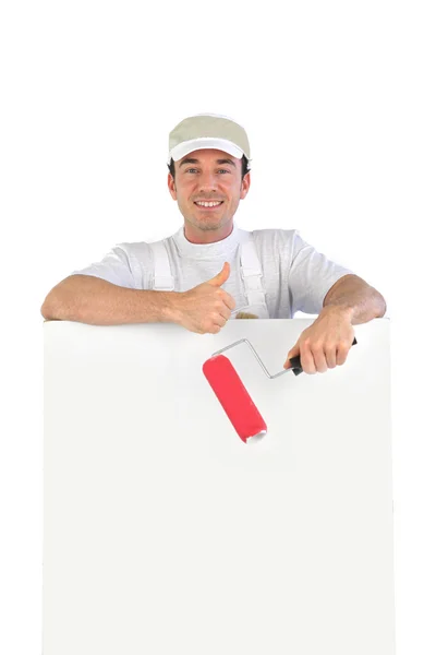 Polegares para cima de um decorador com uma placa em branco — Fotografia de Stock