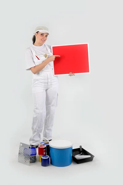 Mulher pintor mostrando papelão vermelho — Fotografia de Stock