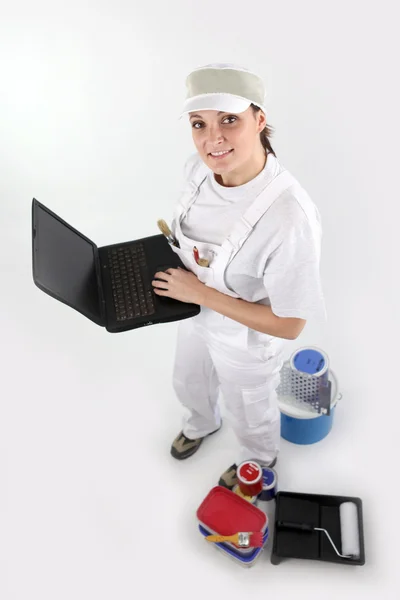Vrouwelijke schilder die een computer vasthoudt — Stockfoto