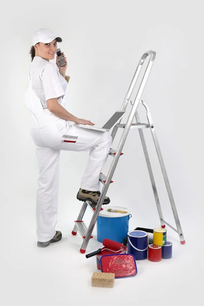 Female decorator with a phone and laptop — Stock Photo, Image