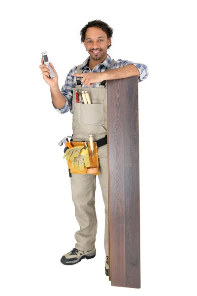 Férfi állt laminált padló egy mozgatható telefon — Stock Fotó