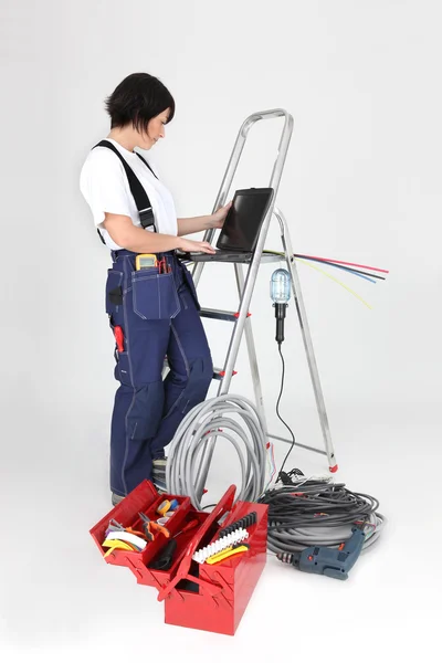 Female electrician working on her laptop — Stock Photo, Image