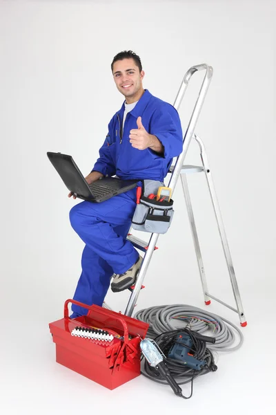 Eletricista masculino com laptop e equipamentos — Fotografia de Stock