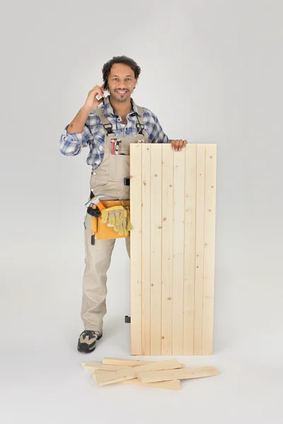 Stolarz stał z drewnianymi drzwiami — Zdjęcie stockowe