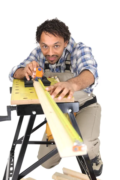 Carpinteiro medindo cuidadosamente prancha de madeira — Fotografia de Stock