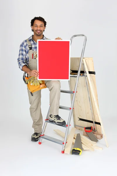 Řemeslník s nástroji a červený panel — Stock fotografie