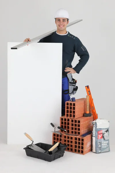 Bricklayer stood by poster — Stock Photo, Image
