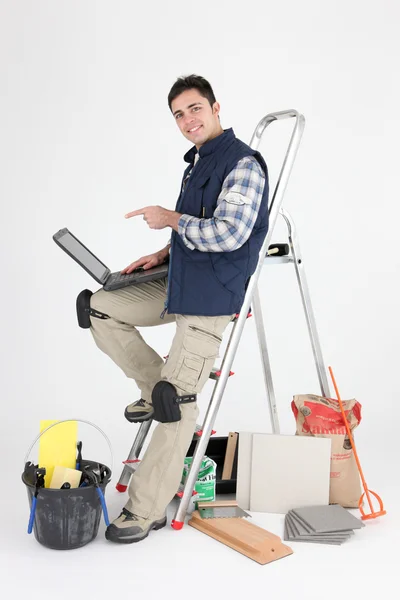 Handwerker zeigt auf seinen Laptop — Stockfoto