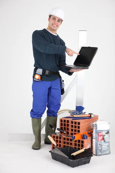 Handwerker zeigt auf seinen neuen Laptop — Stockfoto