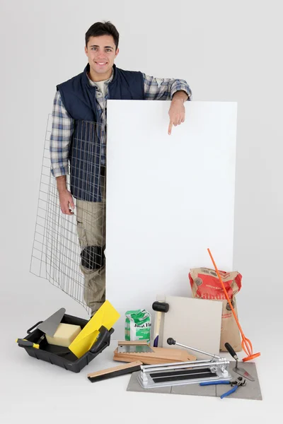 Tiler stood with equipment and poster — Stock Photo, Image