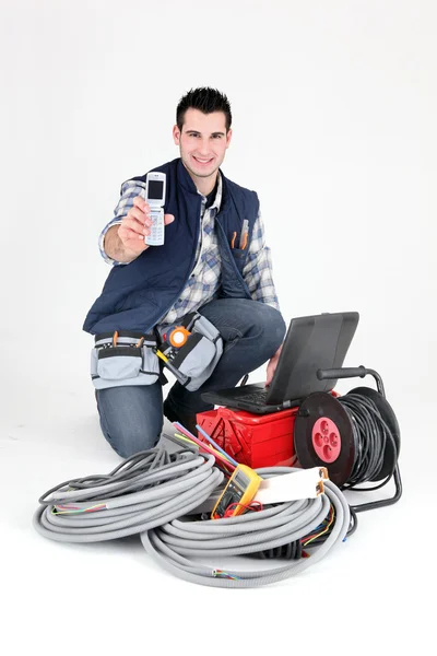 Eletricista feliz mostrando celular — Fotografia de Stock