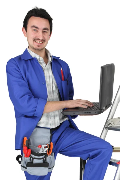 Plumber with computer on stepladder — Stock Photo, Image