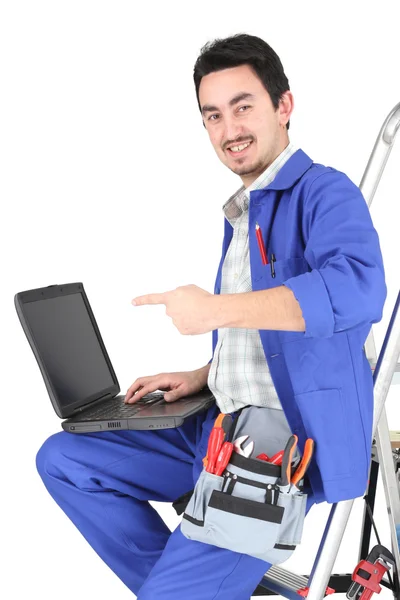 Hombre sentado en escalera con portátil y herramientas de plomería — Foto de Stock