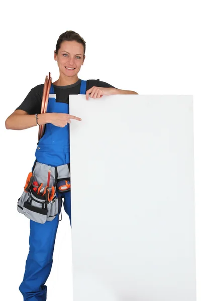 Mulher apontando para placa em branco com caixa de ferramentas — Fotografia de Stock