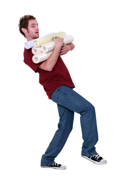 Homem lutando para transportar papel de parede — Fotografia de Stock