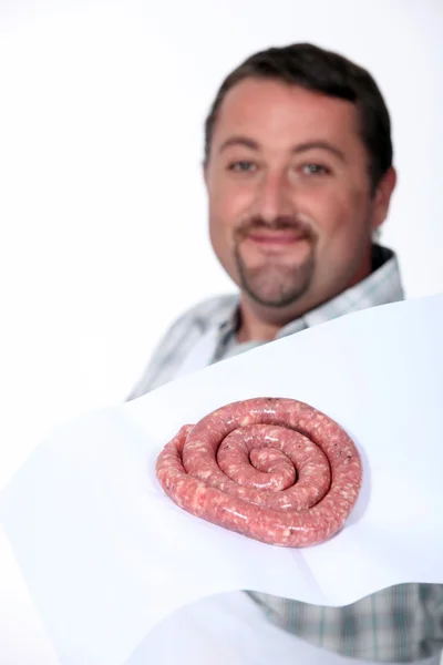 A butcher proudly presenting his sausages. — Stock Photo, Image