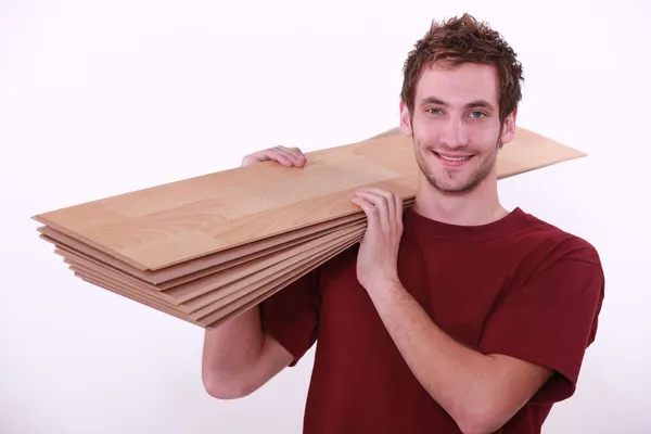 Carpenter carrying floor boards — Stock Photo, Image