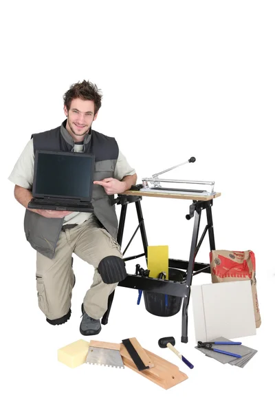 Man met tegels en laptop — Stockfoto
