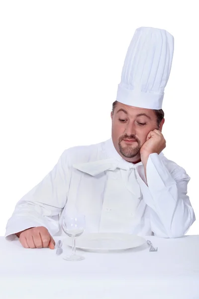 Šéfkuchař pohrdavě při pohledu na prázdný talíř — Stock fotografie