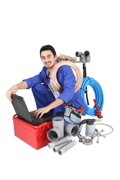 Encanador preparando seu equipamento e seu laptop — Fotografia de Stock