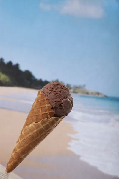 Cono de helado de chocolate de cerca contra el fondo de la playa tropical — Foto de Stock