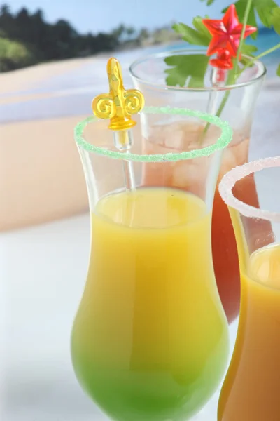 Три глазированных стакана с экзотическими напитками и коктейльными палочками . — стоковое фото