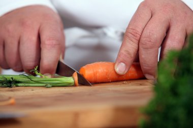 Close-up of chef slicing carrot clipart