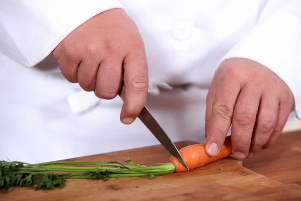 一名厨师切片胡萝卜的特写 — 图库照片