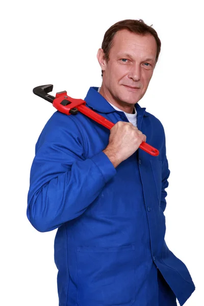 Plumber holding wrench over shoulder — Stock Photo, Image