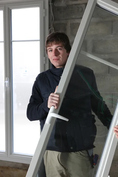 Trabajador instalando ventanas nuevas en un edificio — Foto de Stock