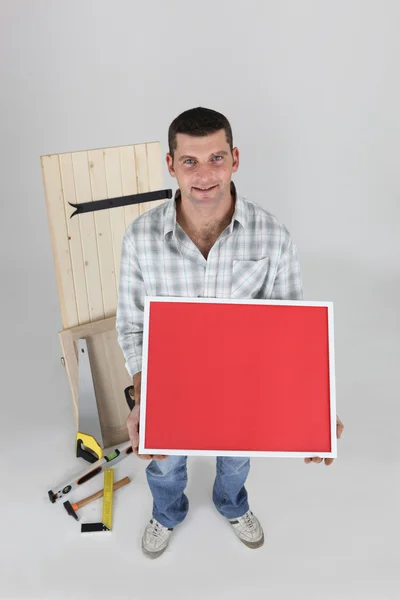 Carpinteiro segurando quadro de imagem — Fotografia de Stock