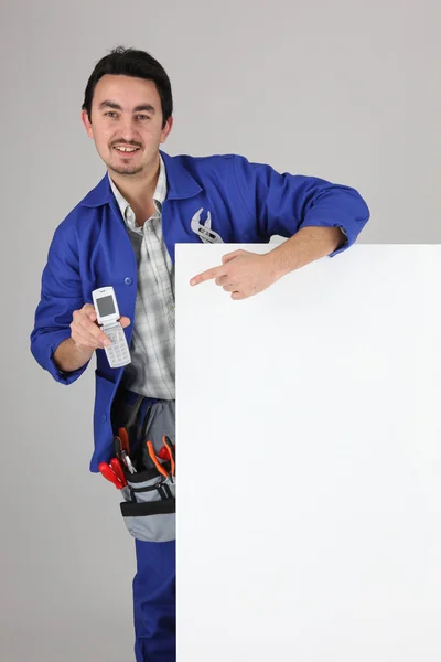 Mann mit leerem Brett, Werkzeuggürtel und Handy — Stockfoto