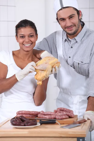 Два м'ясника ріжуть свіже м'ясо — стокове фото