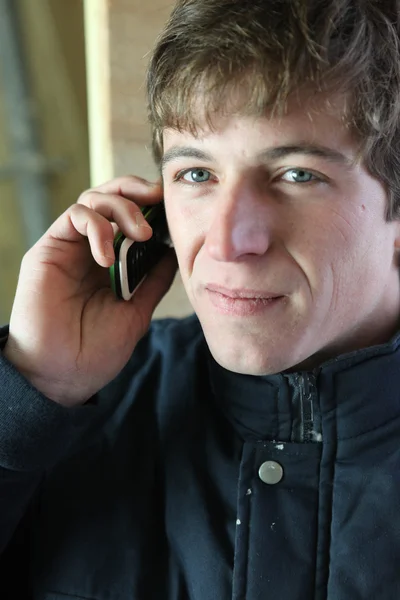Mladý dělník pomocí mobilního telefonu — Stock fotografie