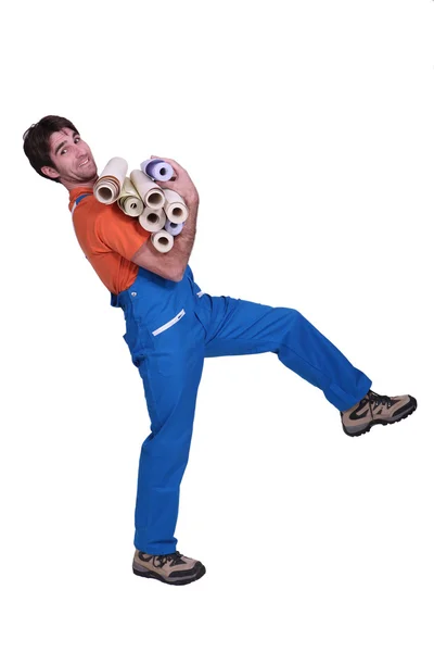 Craftsman carrying rolls of wallpaper — Stock Photo, Image