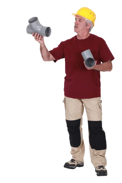 Grauhaariger Klempner mit zwei Ersatzteilen — Stockfoto