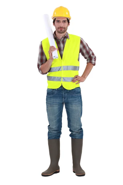 Engineer in a reflective vest with plans — Stock Photo, Image
