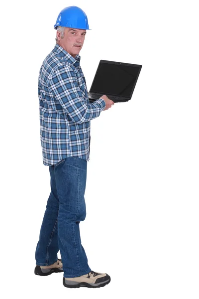 Äldre arbetstagare anläggning laptop — Stockfoto