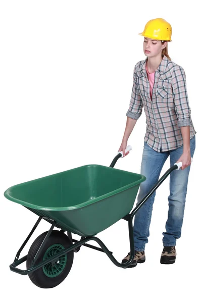 Woman pushing empty wheelbarrow — Stock Photo, Image